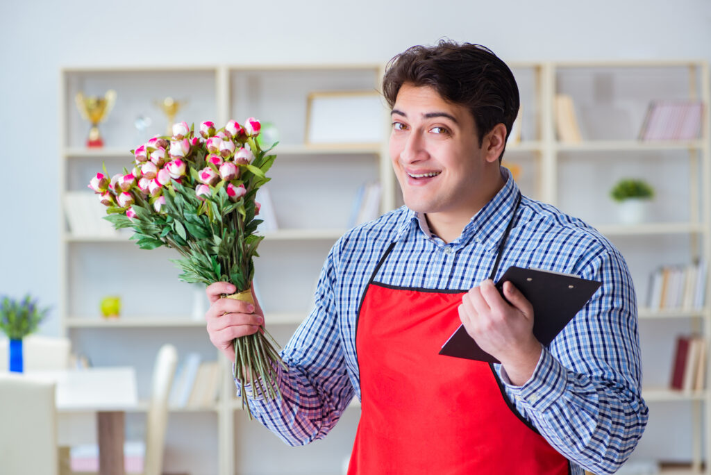 Flower shop assistant offering a bunch of flowers