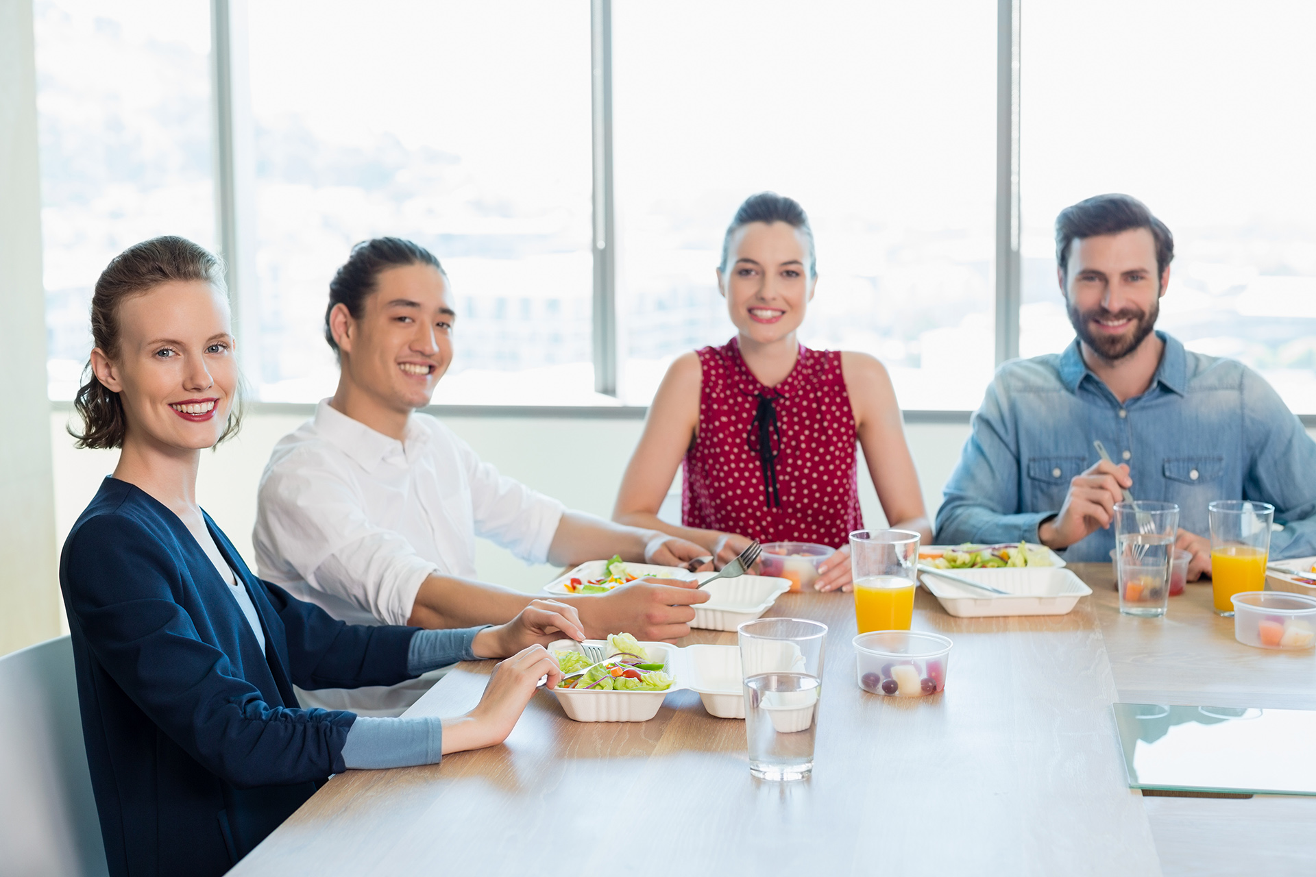 Portrait of smiling business executive having meal in office